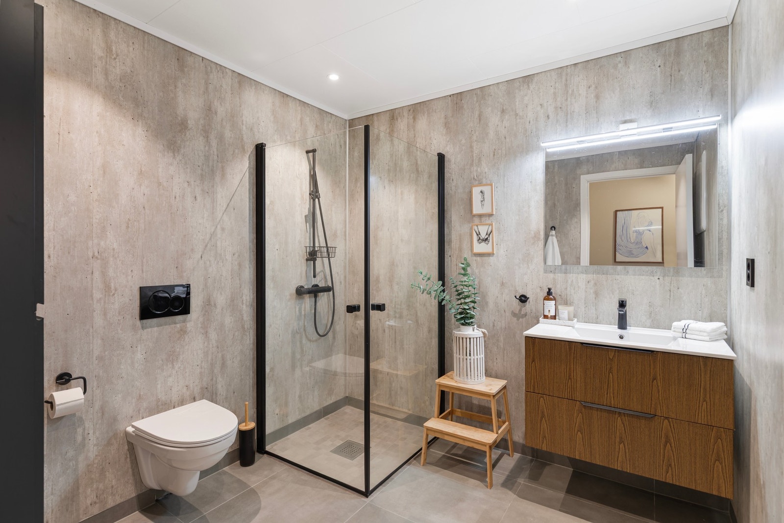 Badet har grå, keramiske fliser på gulv i 60x60 og veggoverflater med betonggrå baderomsplater. Galleribilde