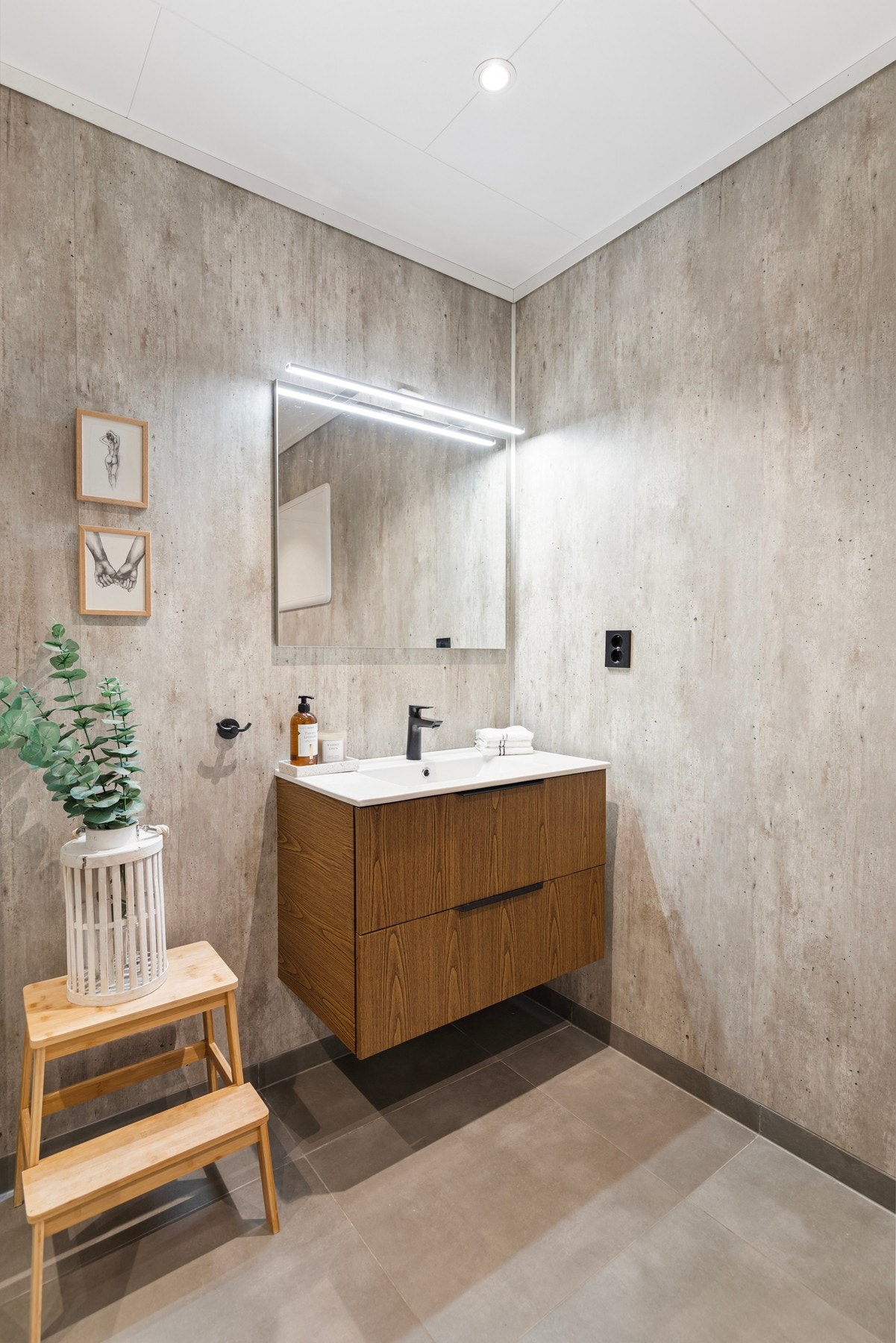 Badet har varmekabler i gulv og er videre utstyrt med spotlights i himling, dusj med dusjvegger, vegghengt toalett, baderomsinnredning og opplegg for vaskemaskin/tørketrommel. Galleribilde