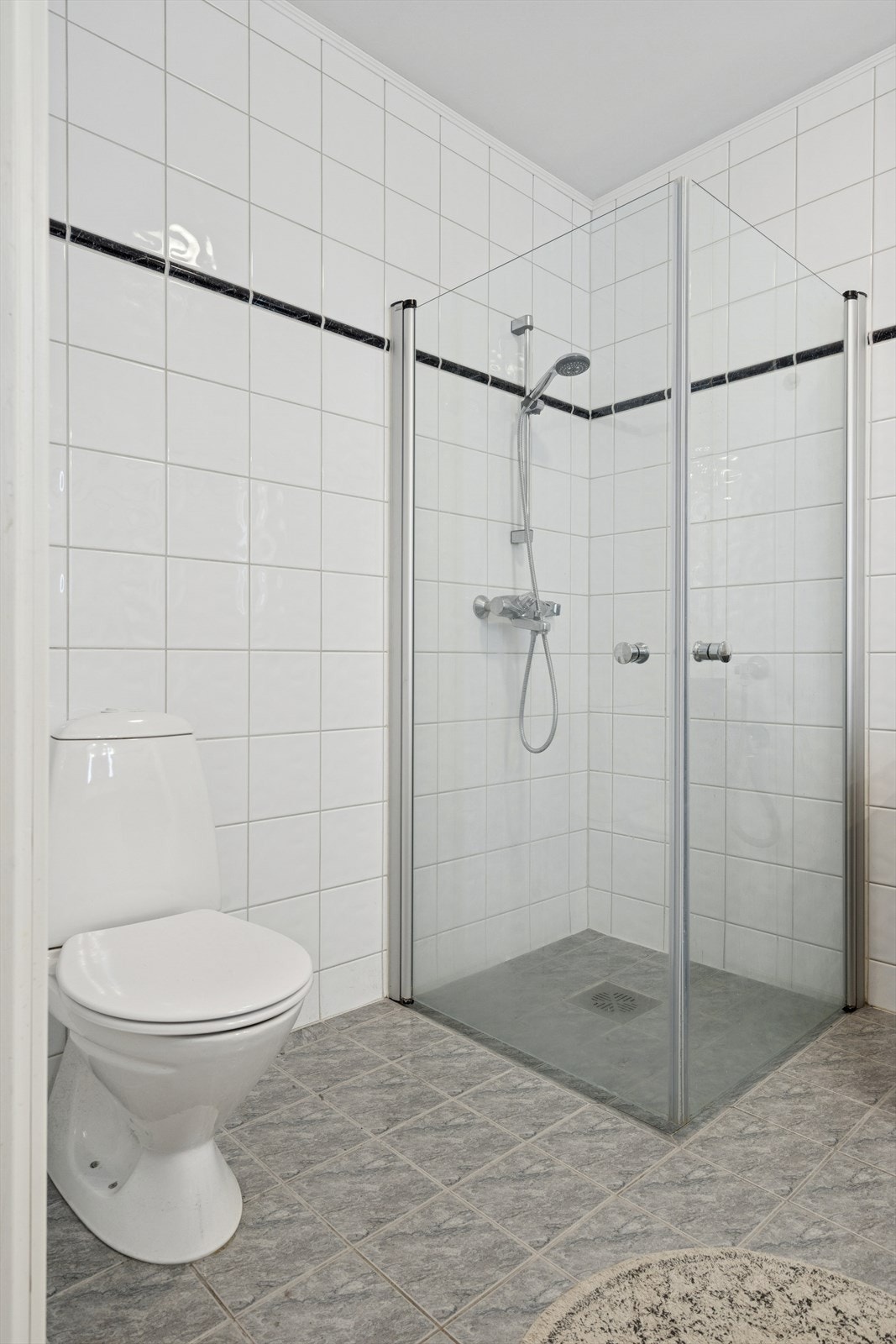 Rommet er utstyrt med toalett, dusjhjørne med glassvegger, baderomsinnredning med servant og speil. Galleribilde