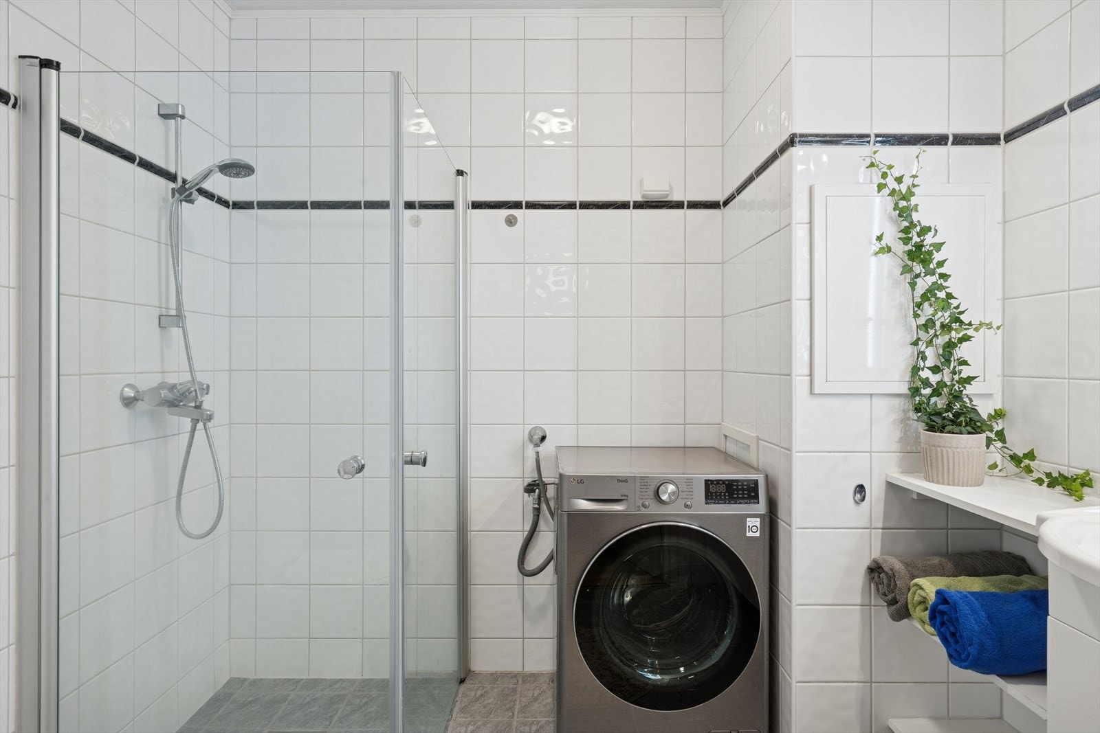 Baderommet er lekkert og praktisk som har flislagte vegger og gulv med behagelige elektriske varmekabler Galleribilde