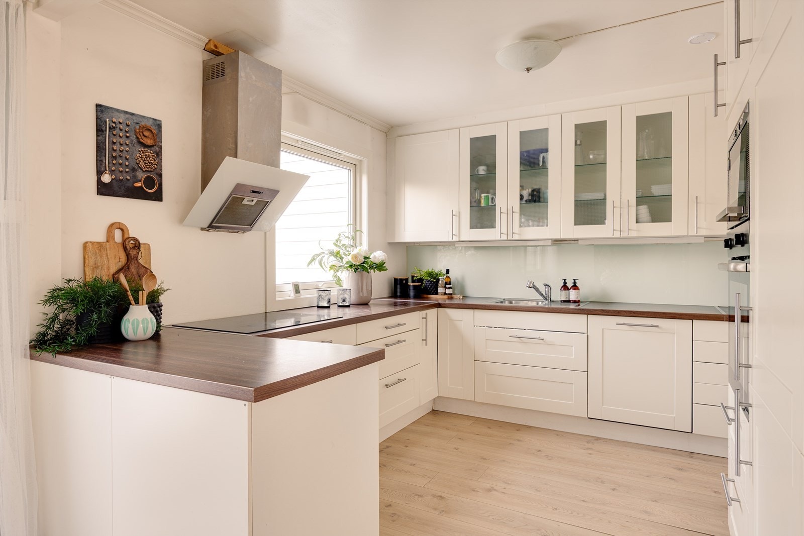 Kjøkkenet har en klassisk og tidløs innredning med profilerte fronter, supplert med enkelte overskap med glassfronter som gir et elegant uttrykk. Galleribilde