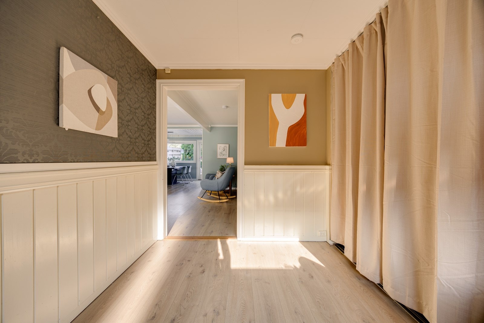 Boligen ønsker deg velkommen med en romslig og innbydende entré med gode garderobeløsninger. Her er det rikelig med plass til yttertøy og sko, og sonen oppleves både praktisk og visuelt pent når du får skjult rotet bak gardiner. Galleribilde