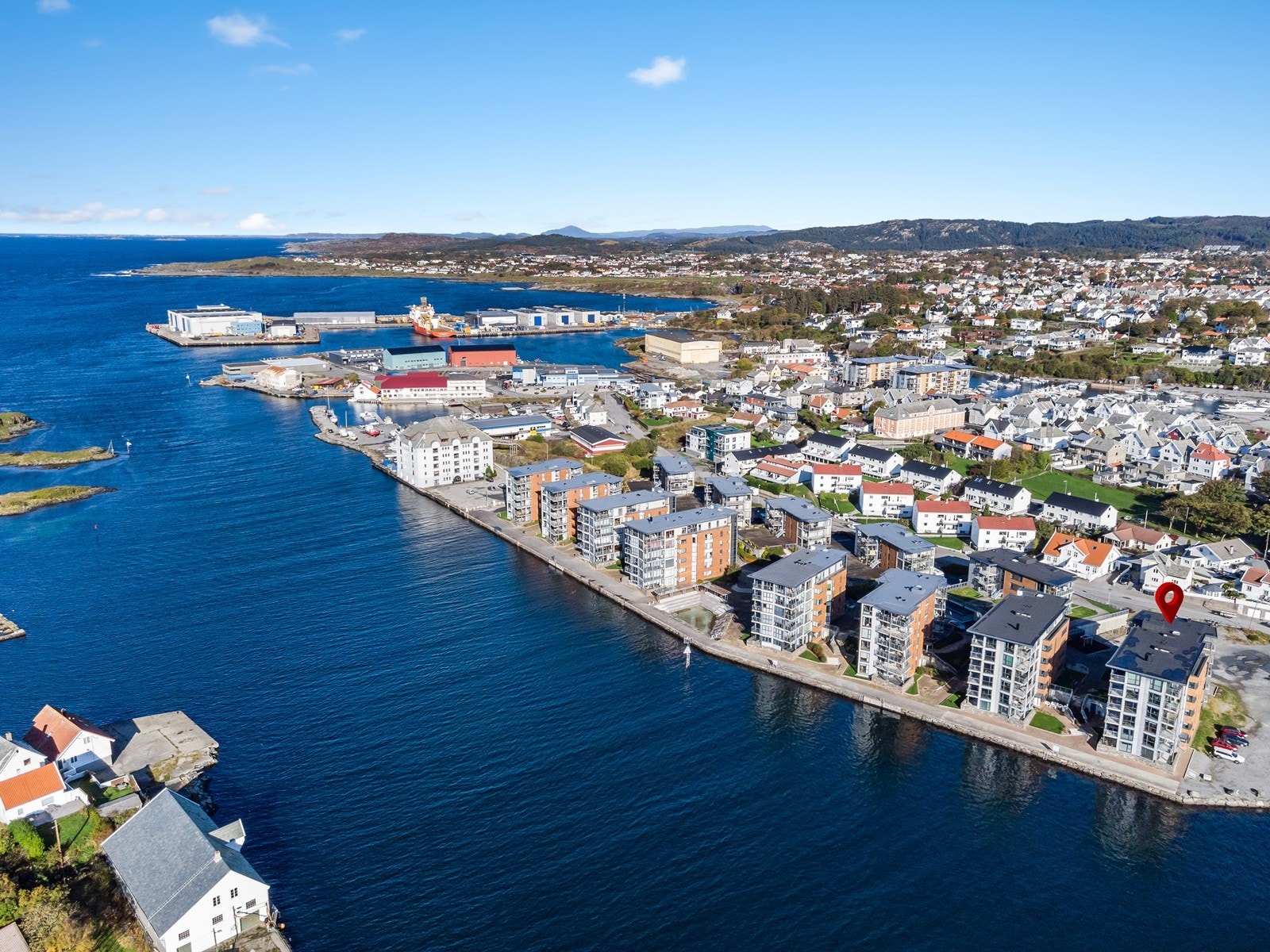 Bakarøy på en solrik dag, bygget der leiligheten er merket med pil Galleribilde