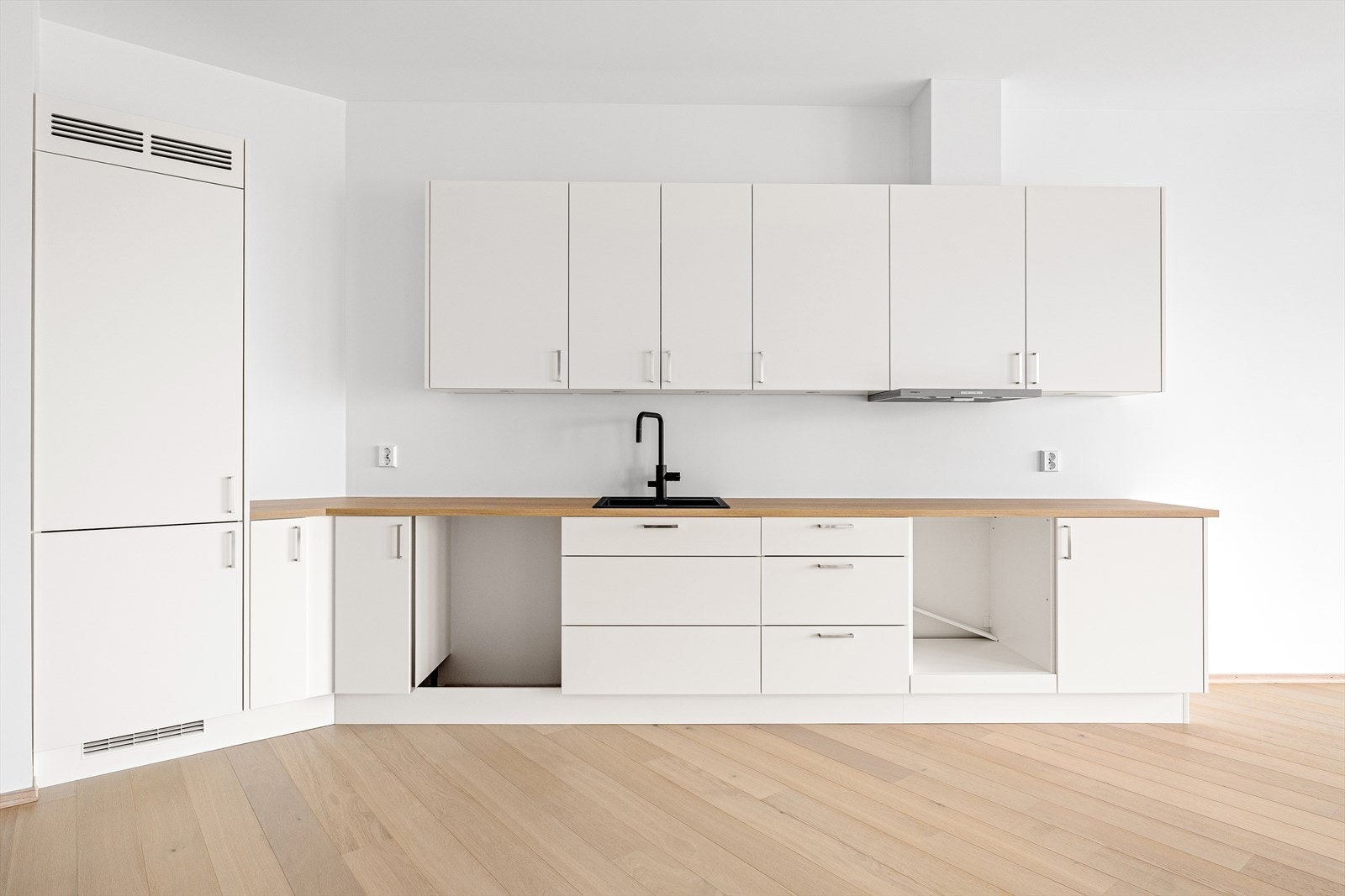 Kjøkkeninnredningen fra Strai Kjøkken med avsatt plass til integrerte hvitevarer som kjøleskap med frysedekm oppvaskmaskin, stekeovn og platetopp. Galleribilde