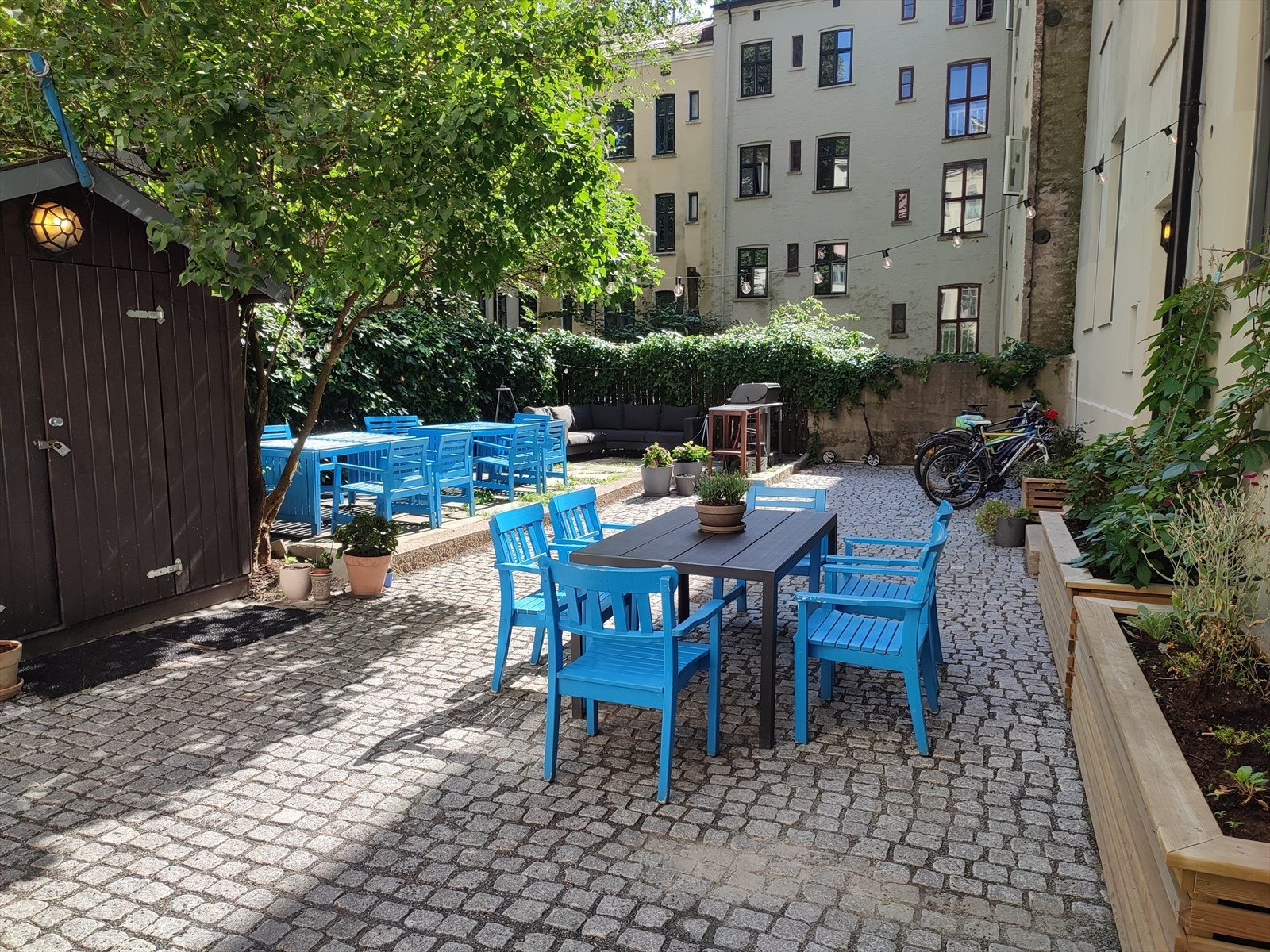 Bygget har en pent opparbeidet bakgård med sitteplasser og grønne, frodige omgivelser. Galleribilde