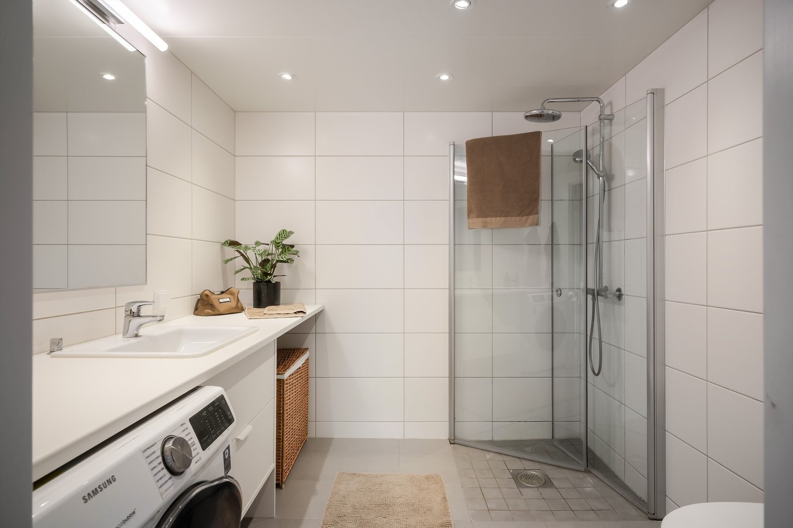 Badet er flislagt med hvite fliser på vegger og grå fliser på gulv. Galleribilde