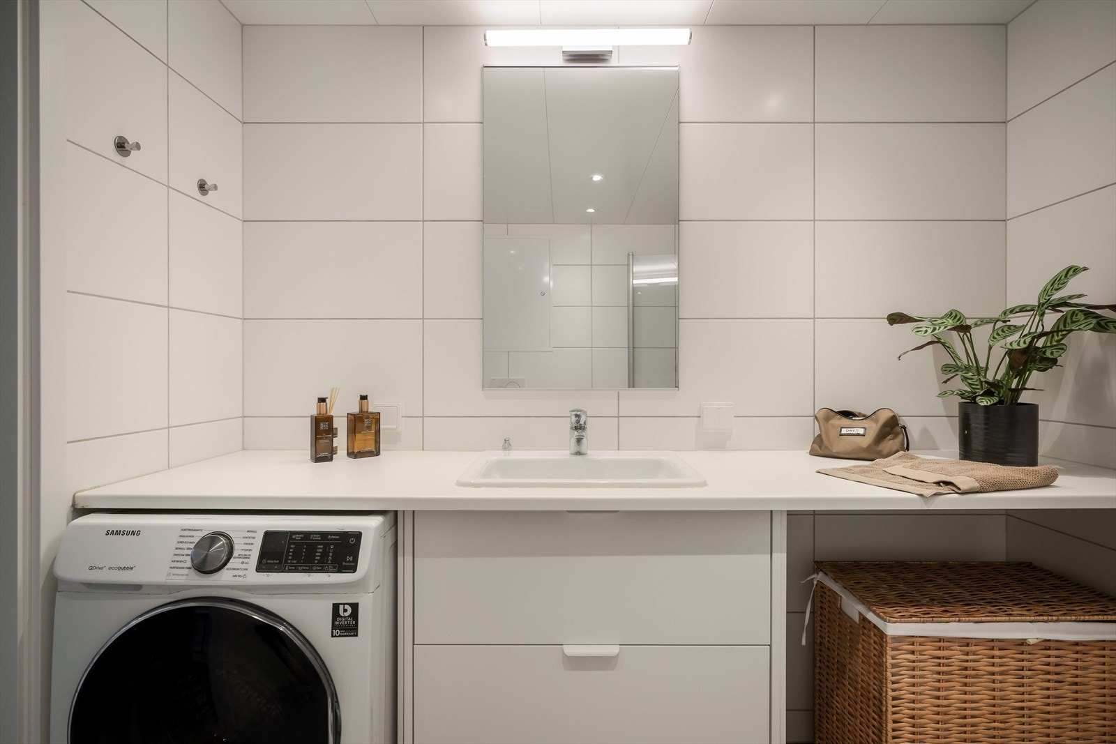 Her er det innredet med dusjhjørne, servant med stor benkeplate, toalett og opplegg for vaskemaskin Galleribilde