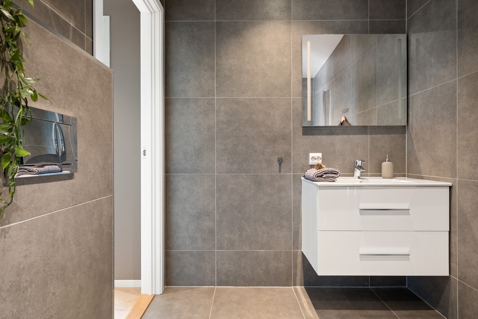 - Innredet med servantmøbel, speil med integrert belysning, toalett og dusjhjørne med glassdører - Galleribilde