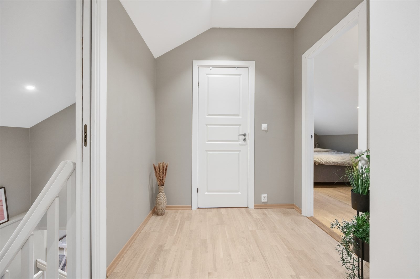 Trappen fører opp til en lys loftsstue som gir tilgang til etasjens soverom og bad. Galleribilde