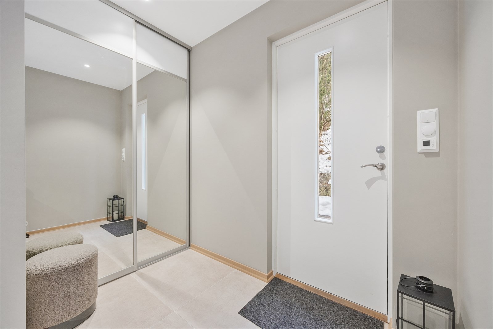 Lys og innbydende entré med skyvedørsgarderobe for effektiv oppbevaring. Galleribilde