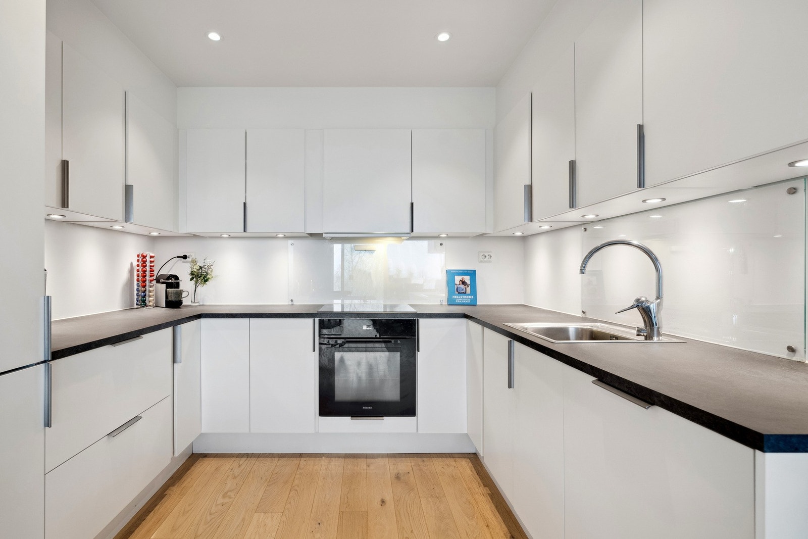 Moderne, funksjonelt kjøkken med integrerte hvitevarer. Galleribilde