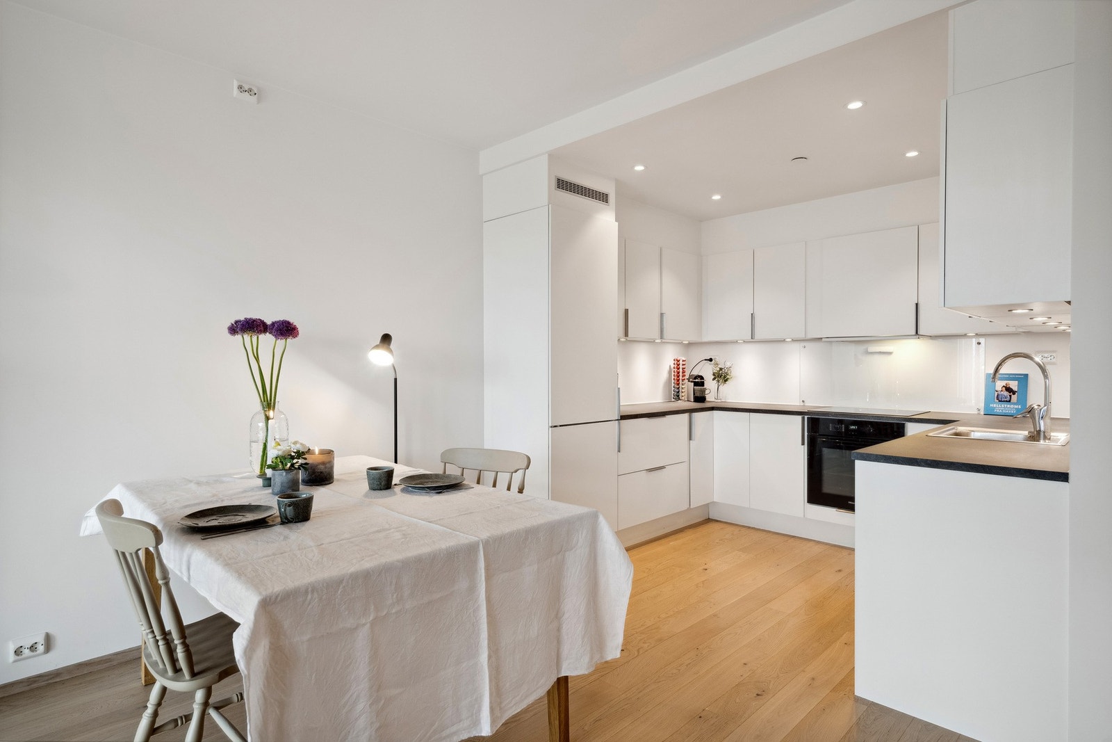 Kjøkkenet ligger praktisk og skjermet til - en smart løsning som gir et ryddig uttrykk i oppholdsrommet. Galleribilde