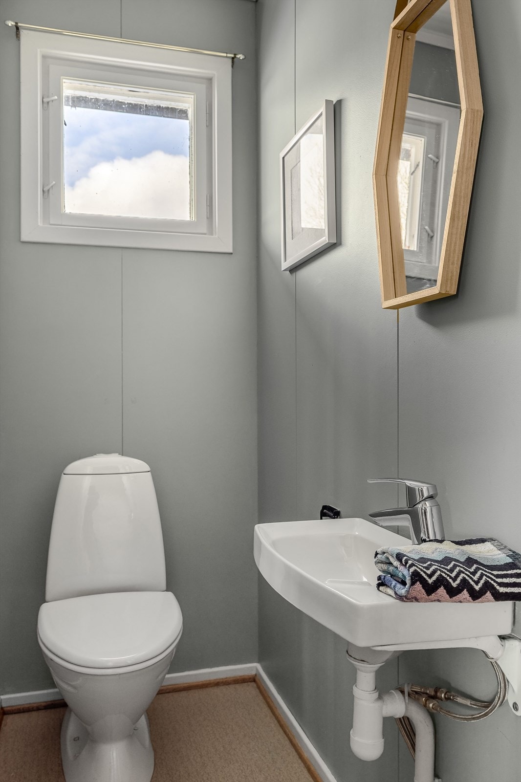 Vegg-i-vegg med baderommet er det et praktisk toalettrom med vegghengt servant og gulvstående toalett. Galleribilde