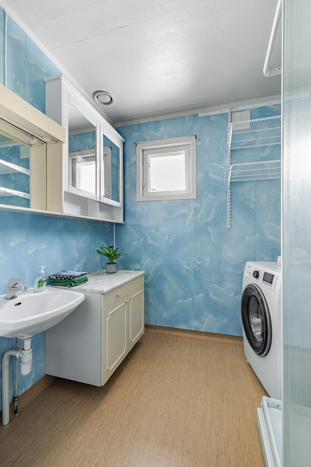 Boligen har et originalt baderom med vinylbelegg på gulv, våtromsplater på veggene og oppvarming via stråleovn på vegg. Galleribilde