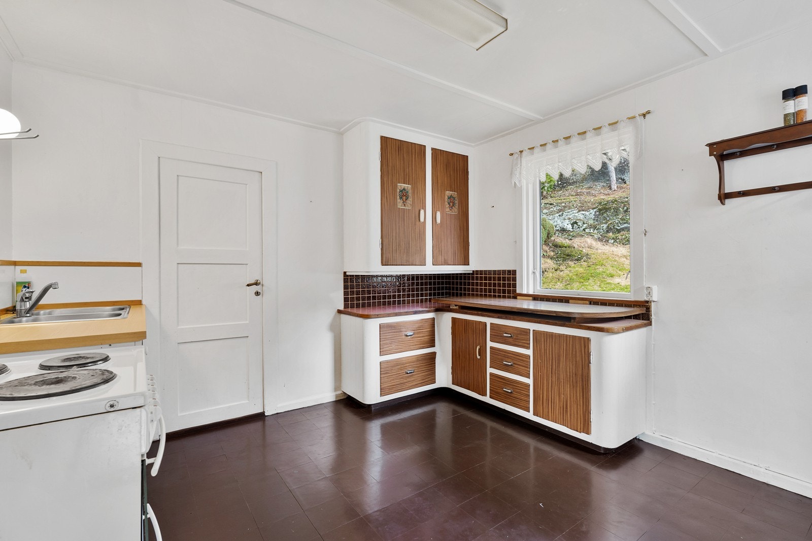 Kjøkkenet ligger i eget rom og er innredet med kjøkkeninnredning på to sider av rommet Galleribilde