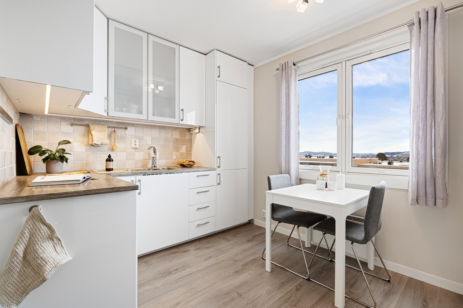 Romslig kjøkken med lys innredning og god plass til frokostbord. Galleribilde