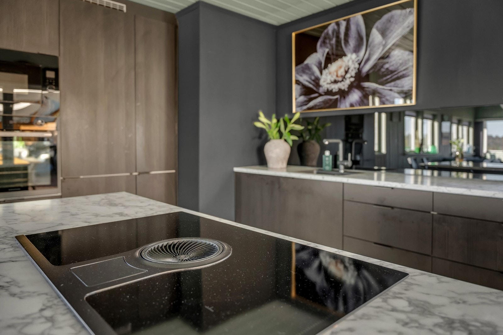 Induksjonstoppen med integrert avtrekksvifte bidrar til et funksjonelt og åpent rom. Galleribilde