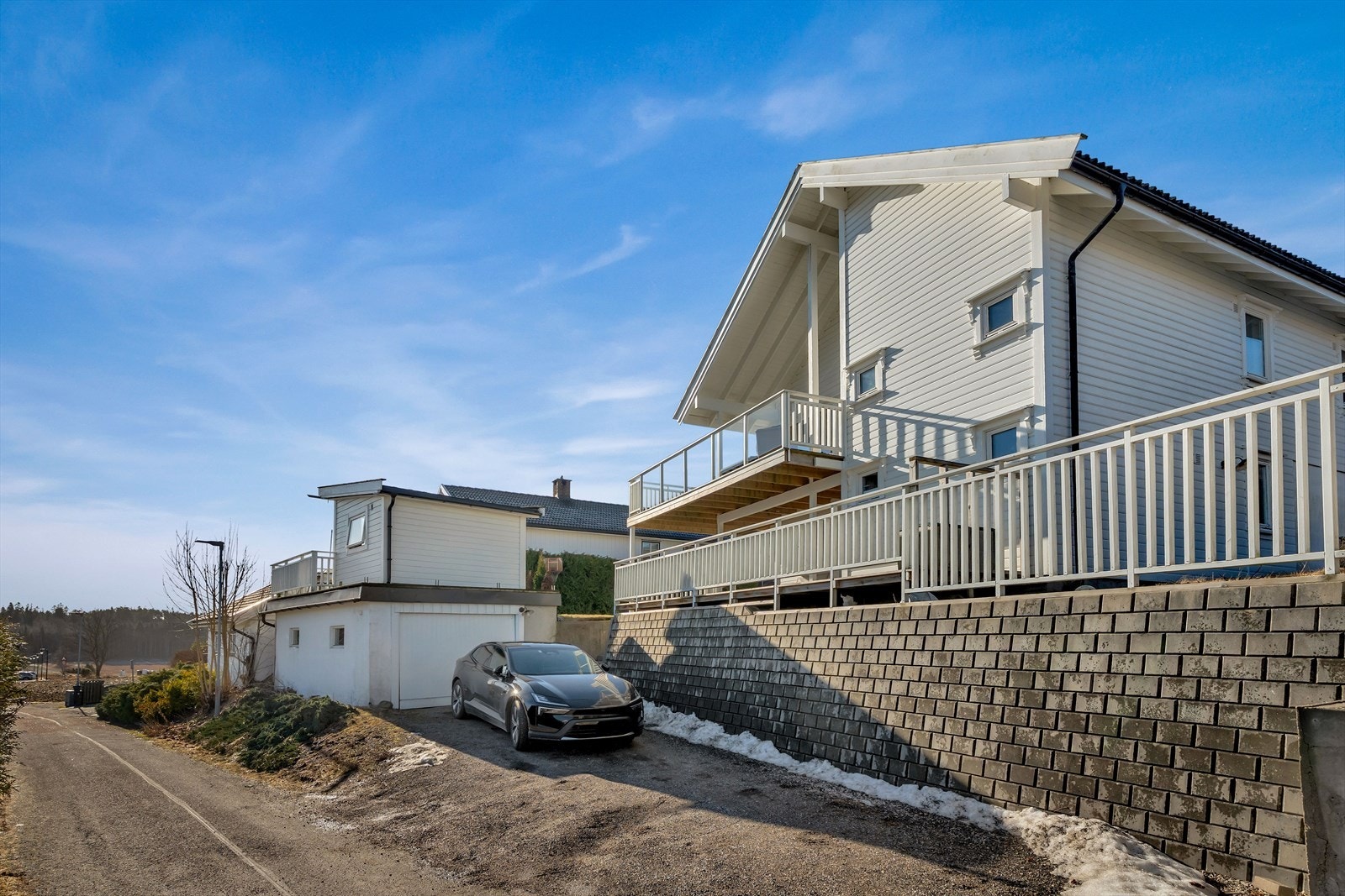Det er gruslagt gårdsplass med parkering på tomten. Galleribilde