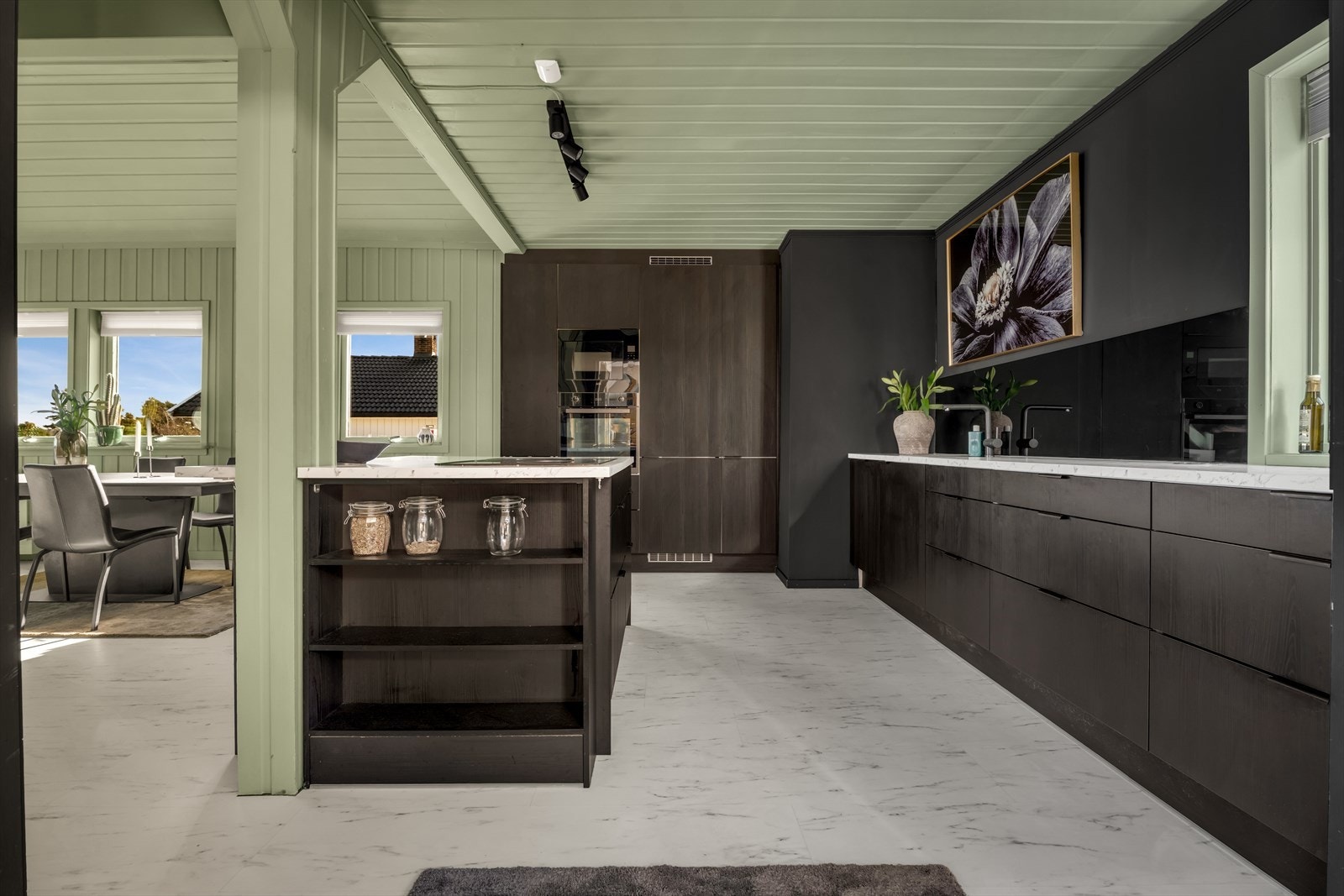 Innredningen har sorte, slette fronter og en laminert benkeplate med underlimt vask. Galleribilde