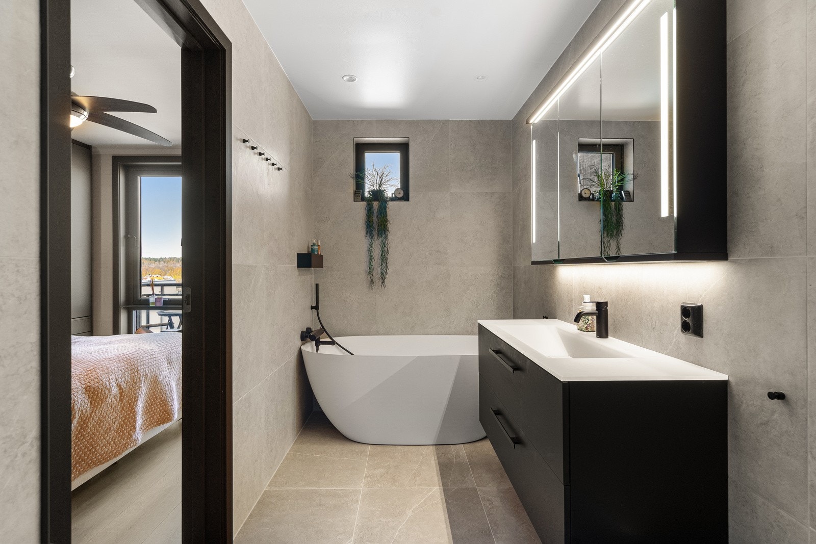 Bad til hovedsoverom med sort, matt servantskap og designbadekar fra Strømberg Galleribilde