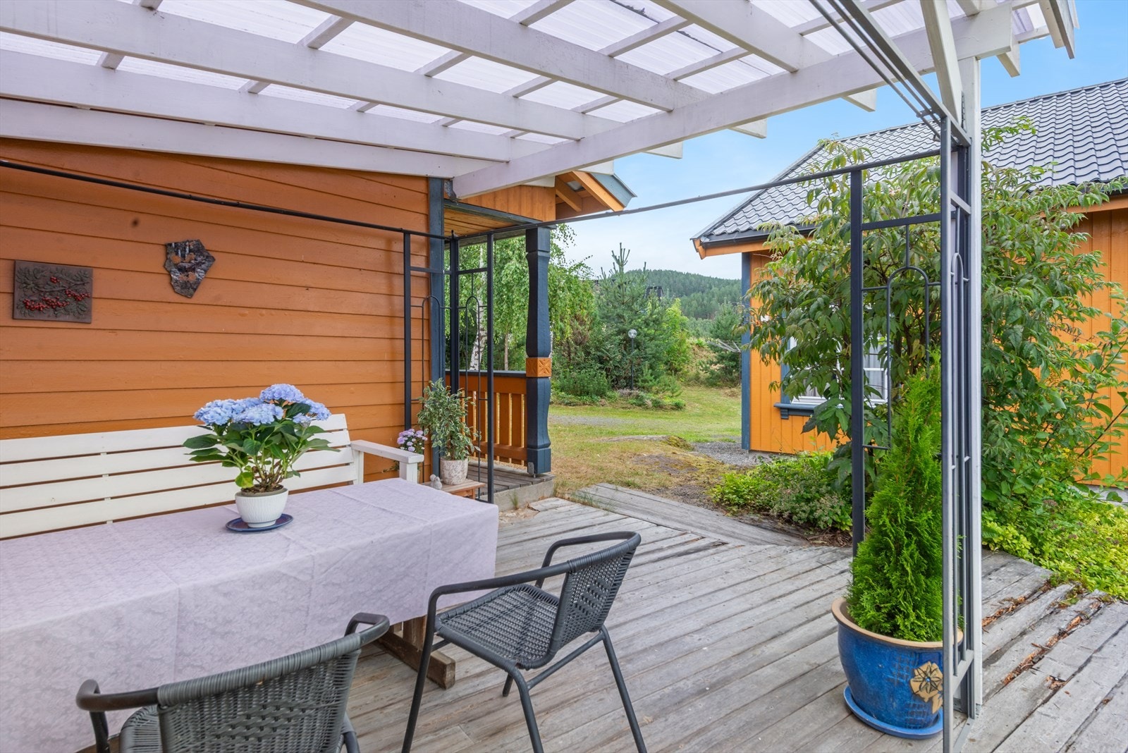 Koselig, overbygd uteplass med tredekke - ideell for lange sommerkvelder og hyggelige måltider. Galleribilde