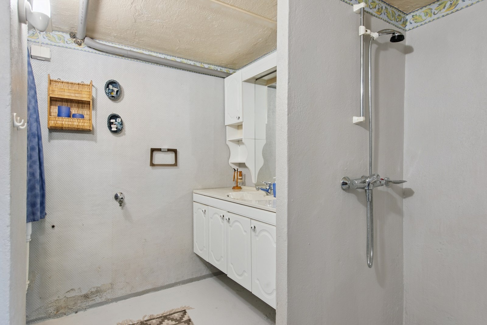 Badet er utstyrt med servantskap, opplegg for vaskemaskin, et dusjhjørne og gulvmontert toalett. Rommet har fått TG3 og må oppgraderes for å tåle normal bruk. Galleribilde