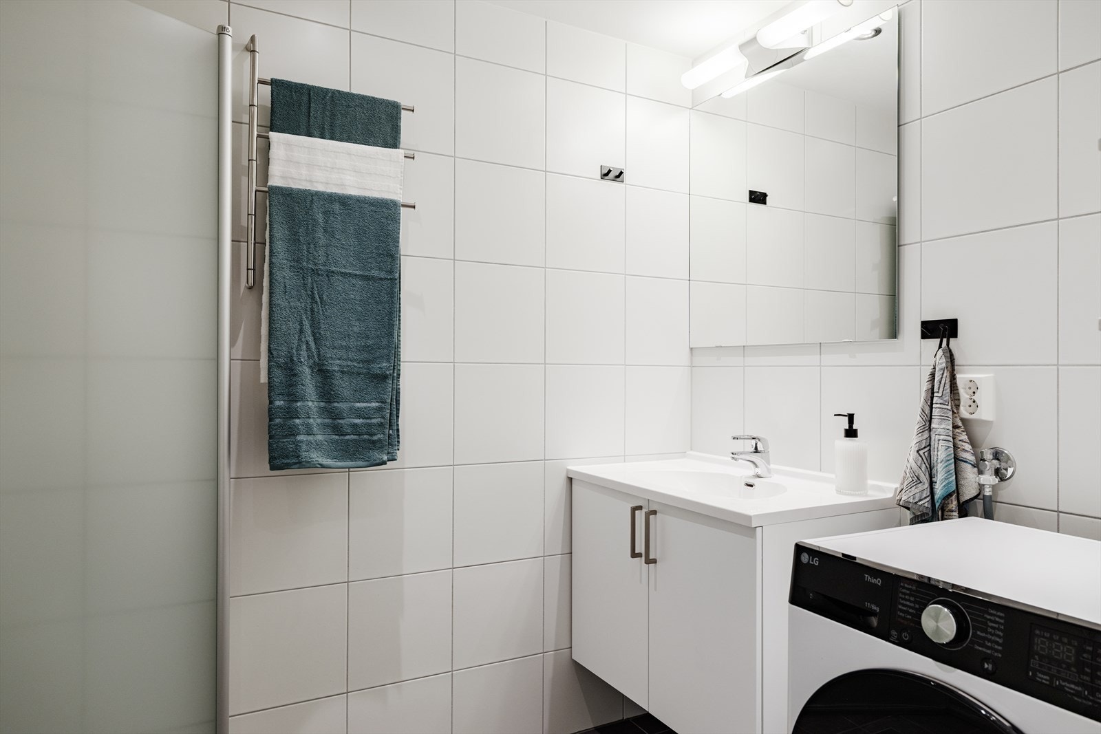 Badet har helflisede overflater, vannbåren gulvvarme og downlightsbelysning i himling Galleribilde