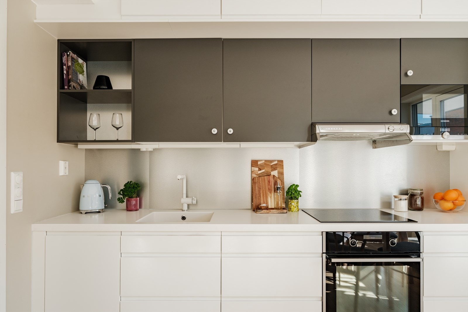 Kjøkkeninnredningen har glatte fronter, samt benkeplate og oppvaskkum i komposittmateriale Galleribilde