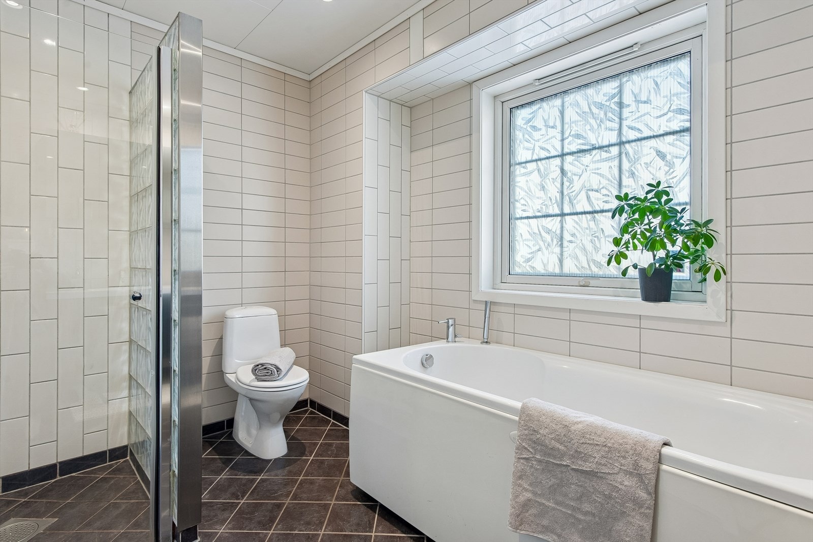 Badet er helfliset og utstyrt med både dusjhjørne og boblebadekar for ekstra velvære. Galleribilde