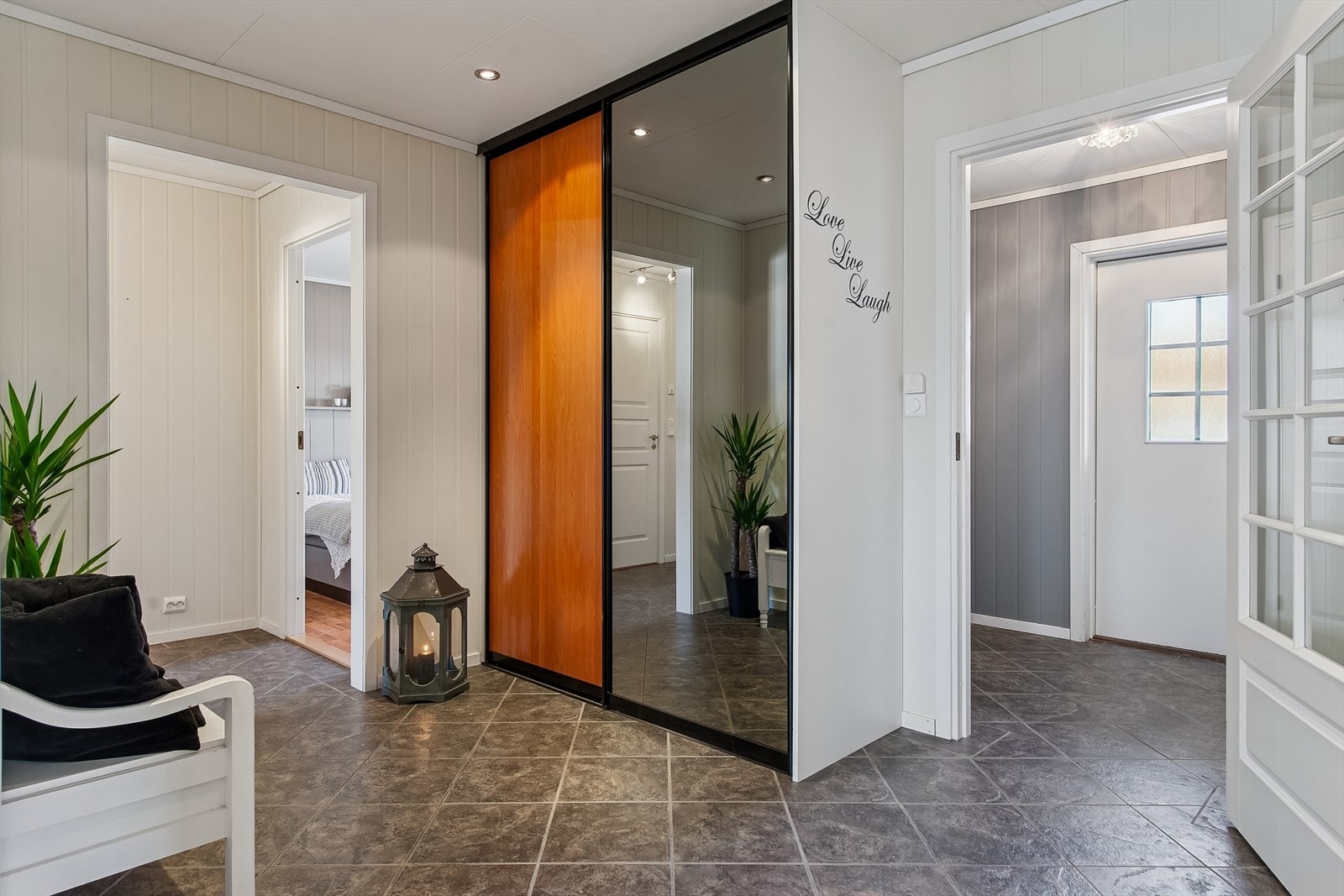 Innergangen har flislagt gulv med varmekabler og god plass til oppbevaring i en romslig skyvedørsgarderobe. Galleribilde