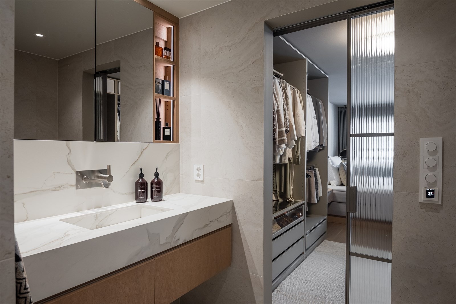 Badet har en stilfull skyvedør i rillet glass fra walk-in-closet, spesialbestilt i samme finish som Tapwell-serien. Galleribilde