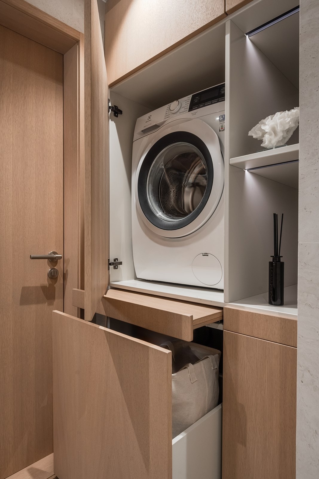 Snekkerbygget innredning på badet med integrert vaskemaskin og praktisk skittentøyskurv. Det praktiske er ivaretatt så vel som det estetiske. Galleribilde