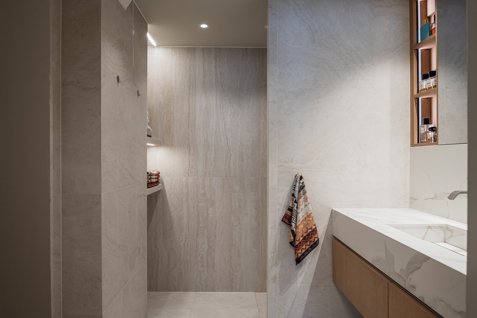 Masterbad fra 2024 med stilren servantinnredning, integrerte hyller og flislagte overflater med varmekabler i gulv. Galleribilde