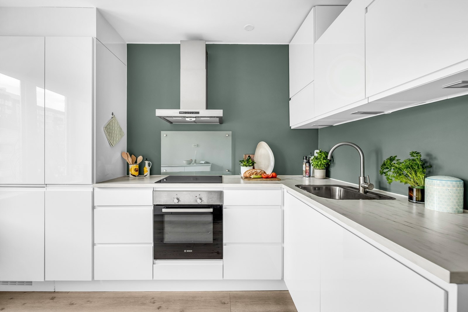 Kjøkkeninnredningen har glatte fronter og laminat benkeplate med nedfelt oppvaskkum. Det er belysning over benkeplaten som gir gode arbeidsforhold. Galleribilde