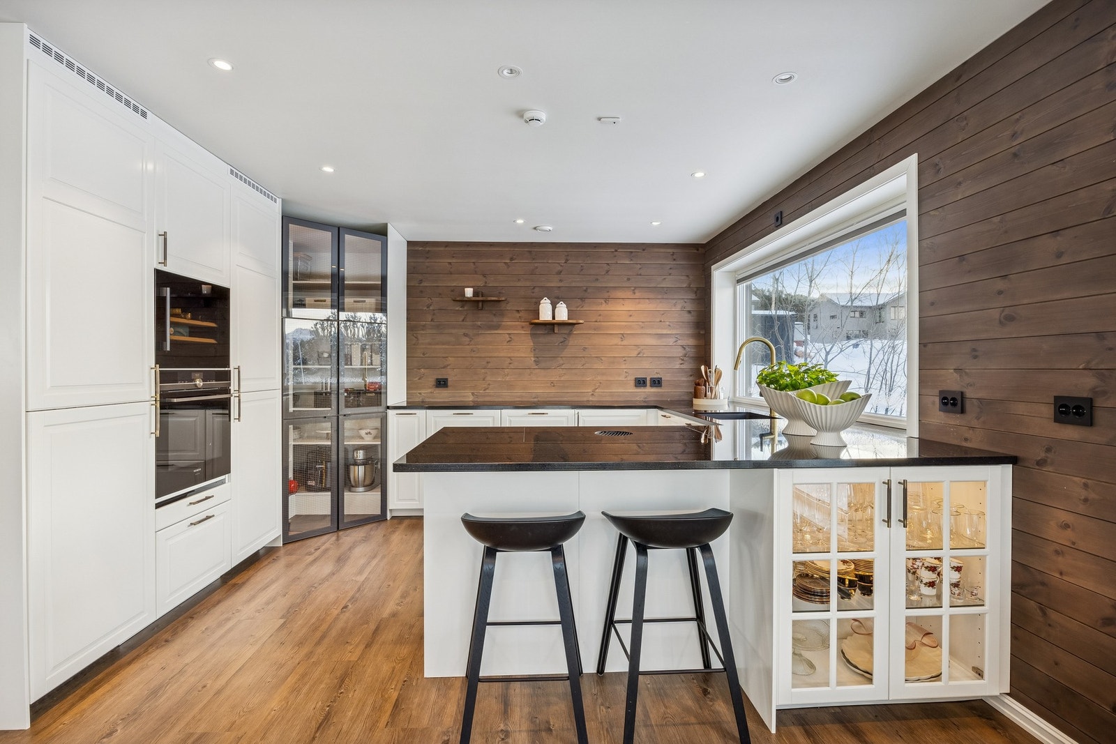 Kjøkken med steinbenkeplate av kvalitet, integrerte hvitevarer og et moderne "spisskammer". Galleribilde