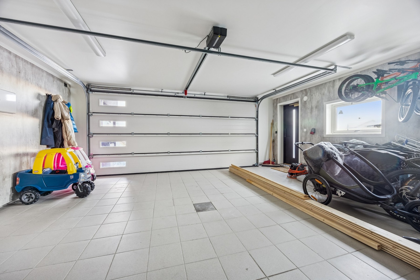 Garasje med fliser på gulv, sluk og gulvvarme - det er direkte adkomst fra garasje inn i boligen. Galleribilde