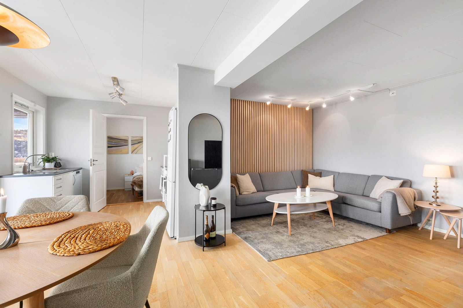 Romslig sofahjørne med plass til stor sitteseksjon. Lekker kontrastvegg med lyse spiler. Galleribilde