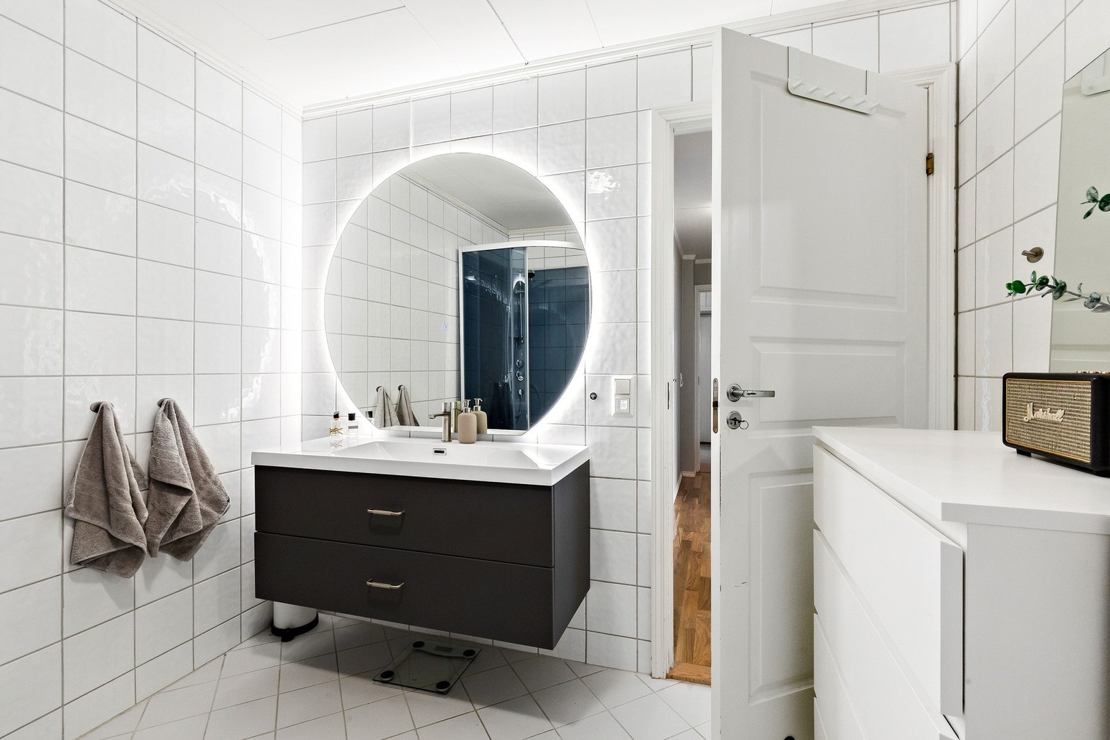 Romslig og pent flislagt bad på hele 5,9 kvm. Innredningen og det store lysspeilet er nytt fra 2025. Lysspeilet har innebygget "antidugg-funksjon". Galleribilde