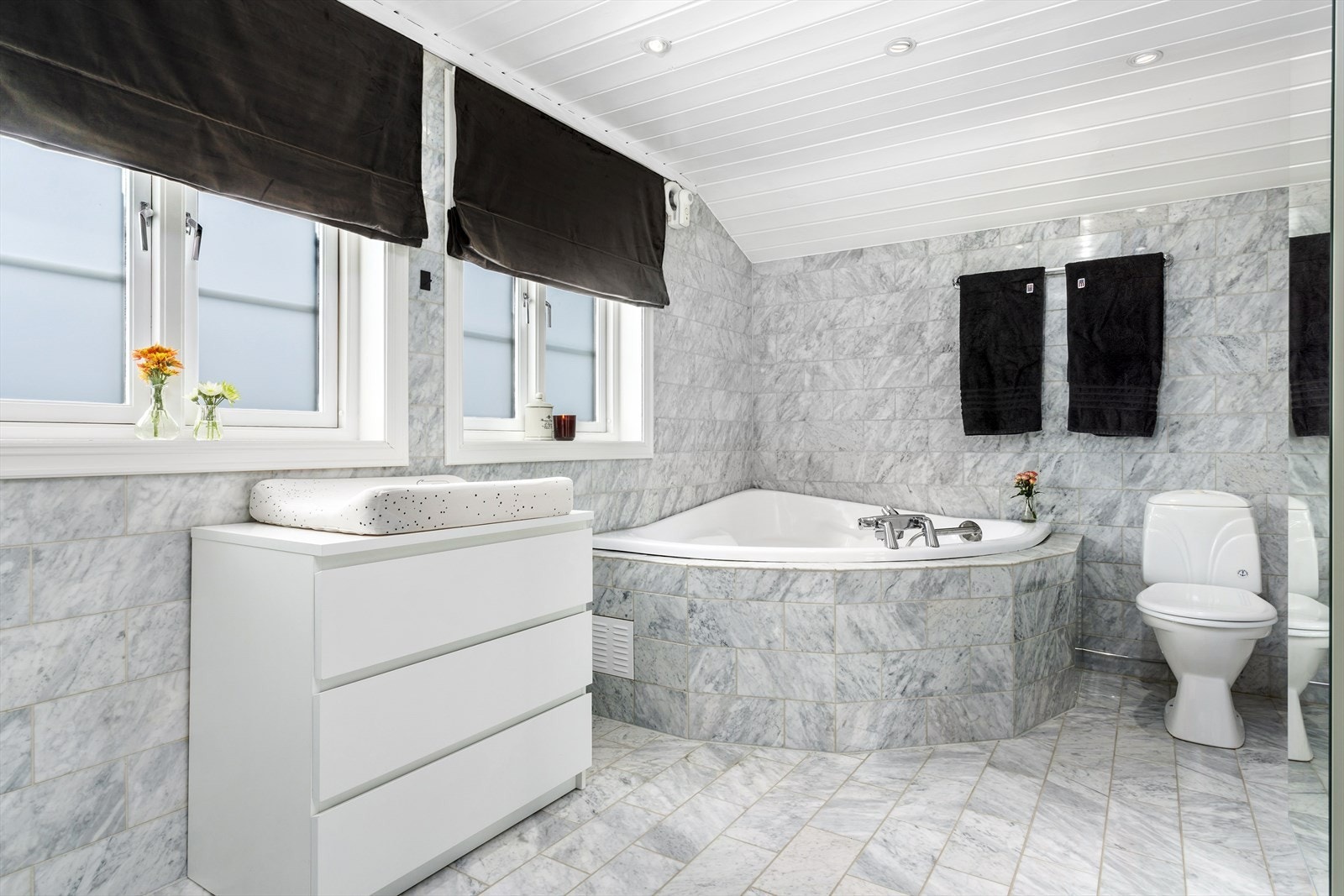 Badet har innmurt badekar, samt dusjkabinett og toalett. Galleribilde