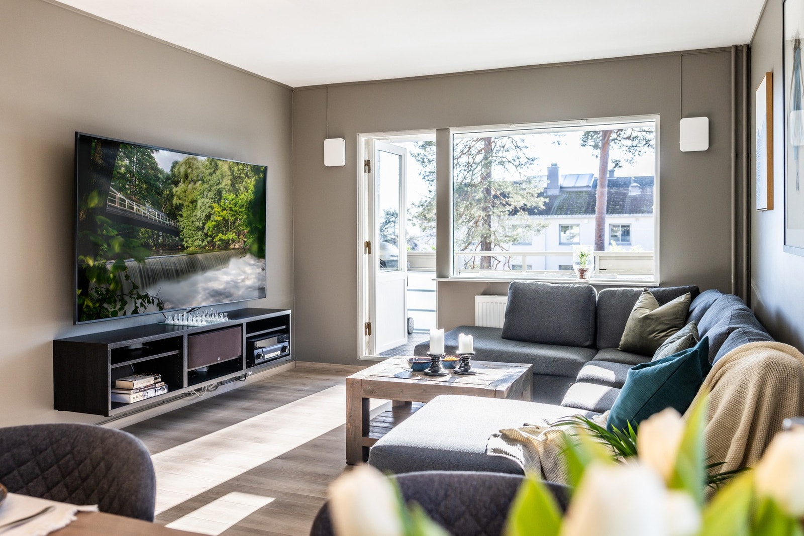 Lys stue med store vinduer, åpen løsning mellom stue og spiseplass, utsikt mot nabolaget. Galleribilde