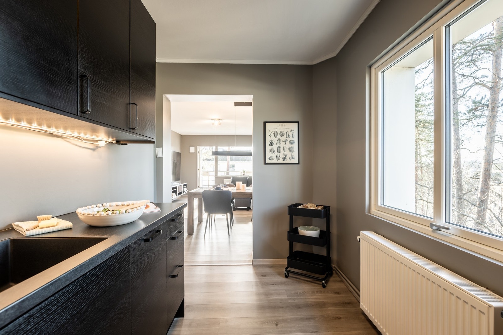 Kjøkkenet har moderne skap og benkeplate, og gir utsikt til spisestue gjennom en åpen løsning. Galleribilde