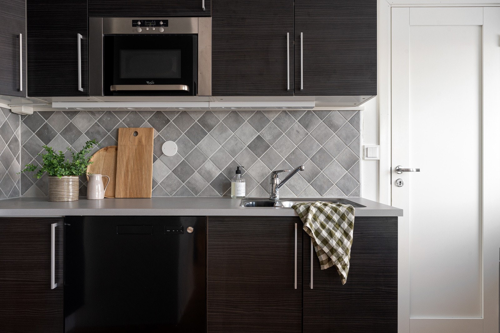 Kjøkkenet er av moderne trekk i mørke farger.