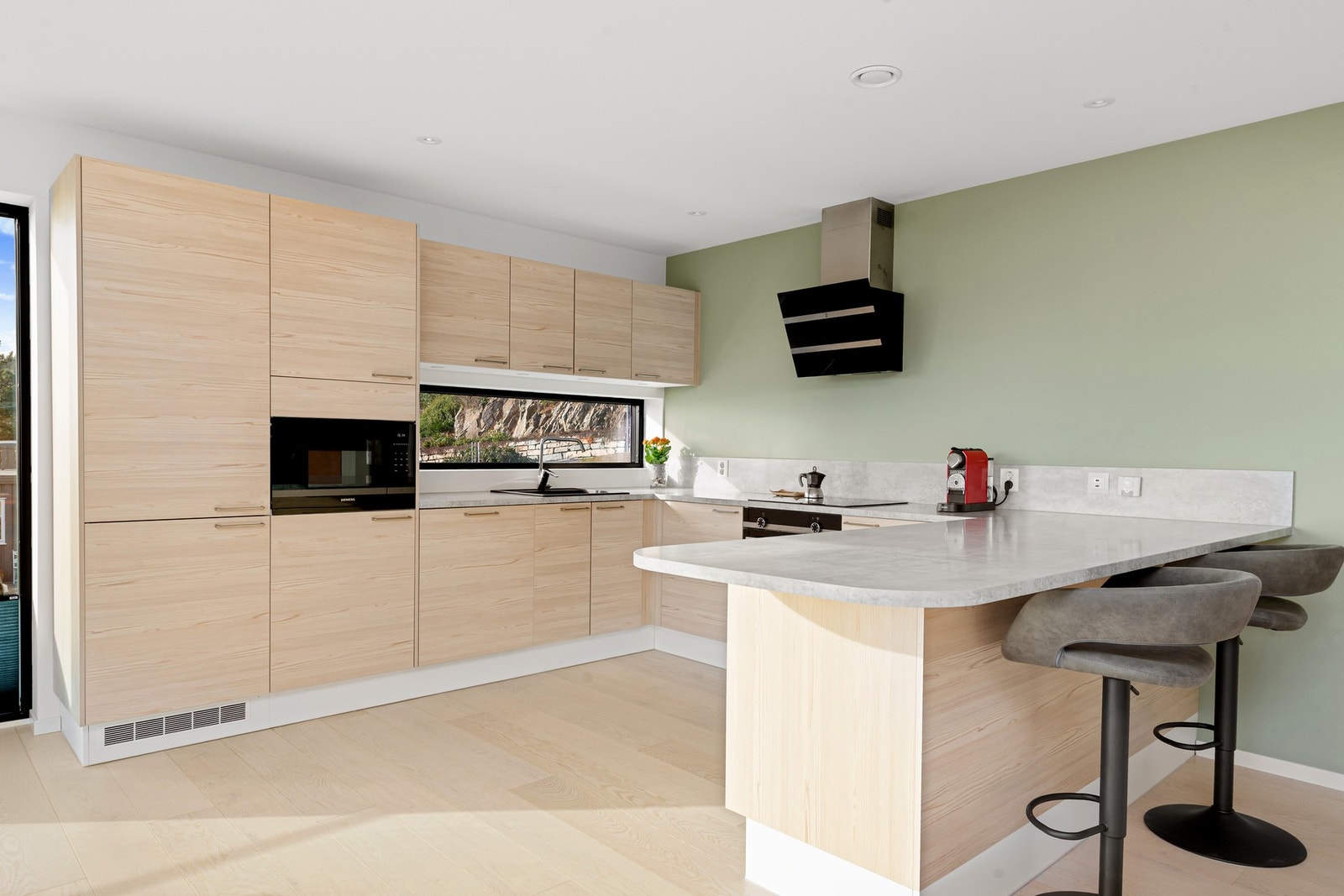 Den åpne løsningen mellom kjøkken og stue gjør rommet godt egnet til både hverdagsliv og sosiale sammenkomster. Galleribilde