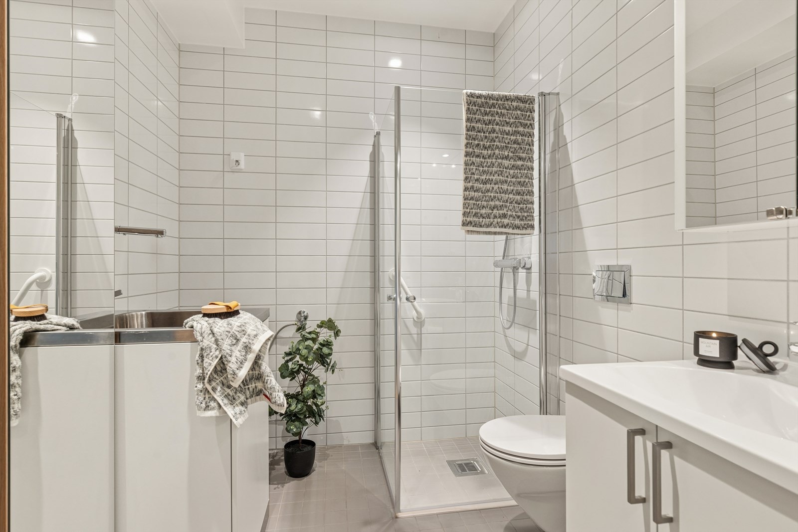 Flislagt bad med dusj med foldedører. Galleribilde