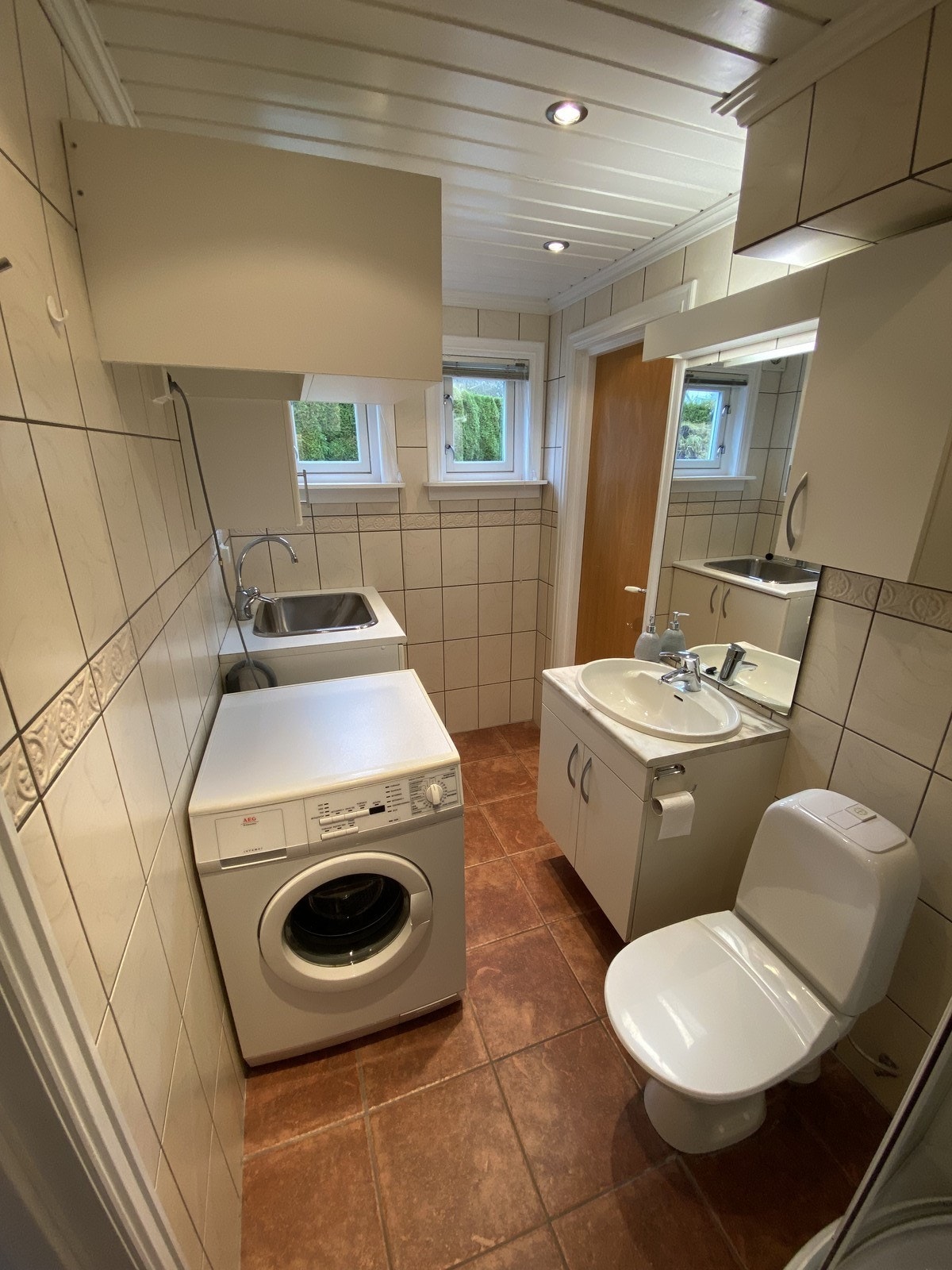 Badet inneholder toalett, servant m/innredning, dusjkabinett, utslagsvask og vaskemaskin. Galleribilde
