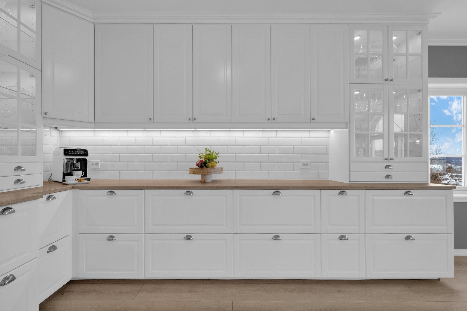 LED-belysning under overskapene gir god arbeidsbelysning, og det er pene fliser mellom benkeplate og overskap. Galleribilde