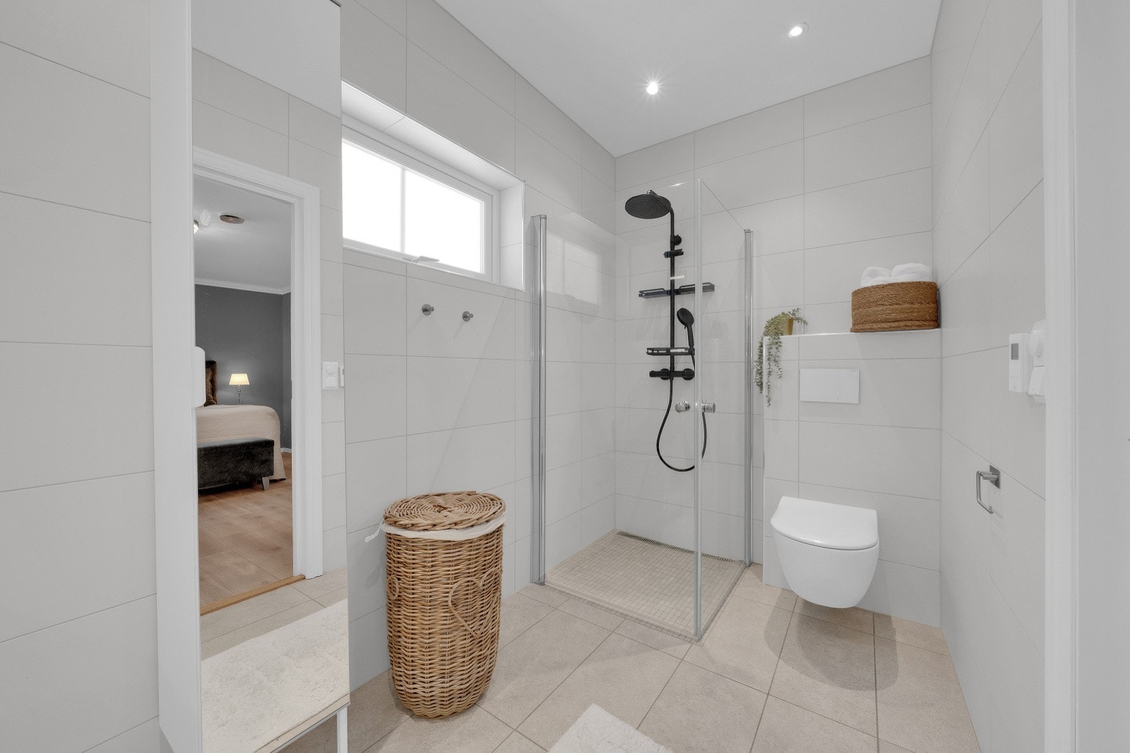 Moderne og delikat flislagt bad med varmekabler i gulv og downlights i himling. Galleribilde