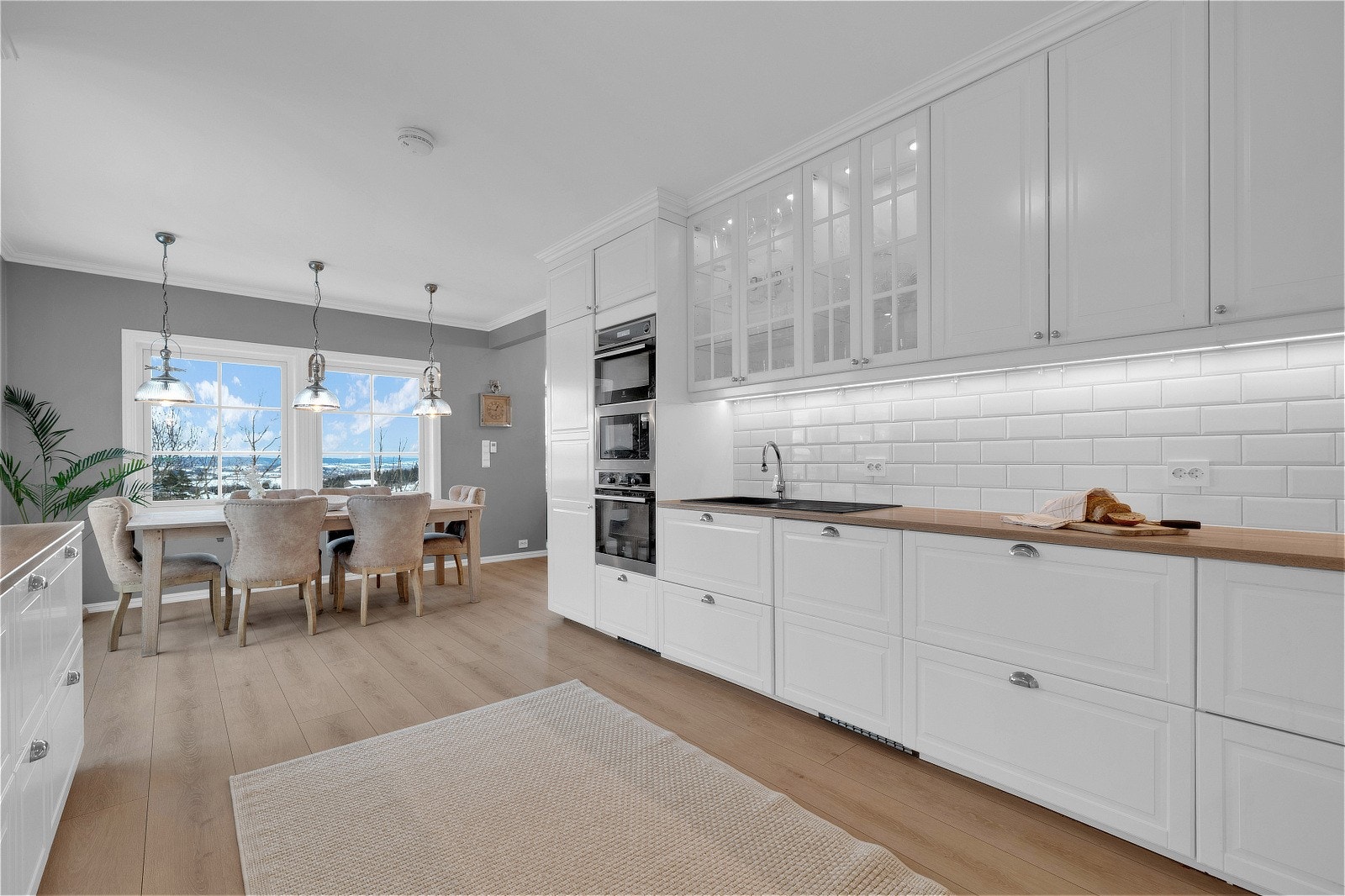 Det er laminat benkeplate med nedfelt sort kum i kunststoff og ettgreps kjøkkenarmatur. Galleribilde