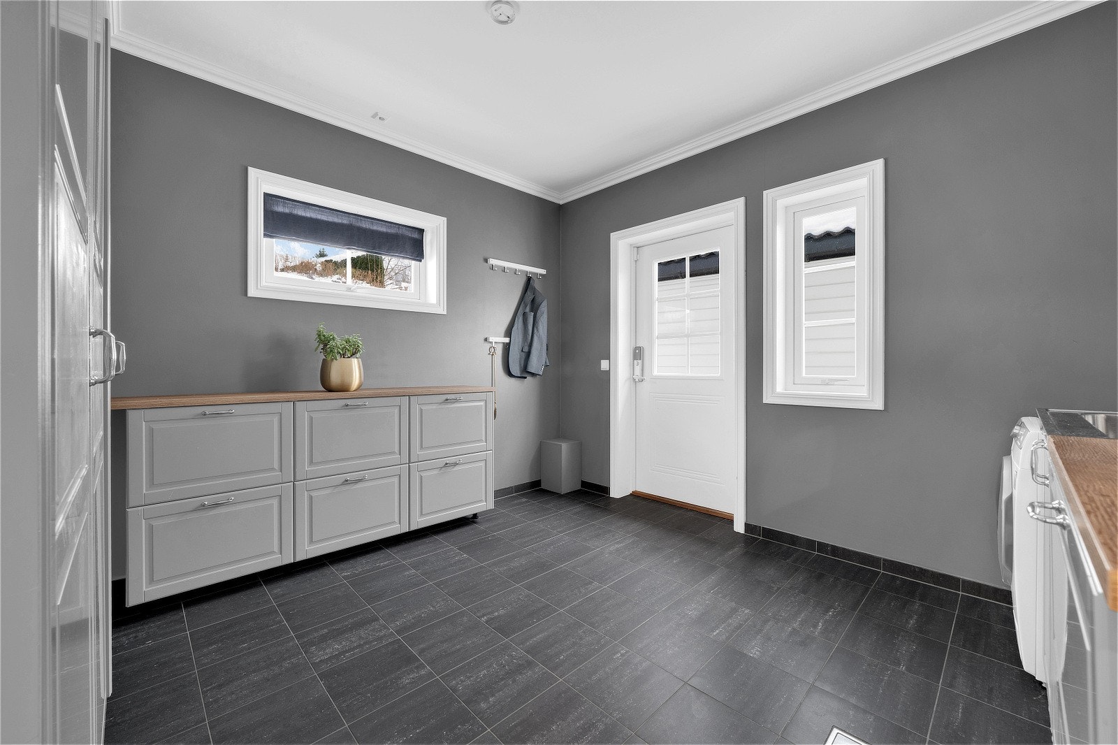 Vaskerommet er romslig og flislagt, med rikelig skapplass for praktisk oppbevaring. Galleribilde