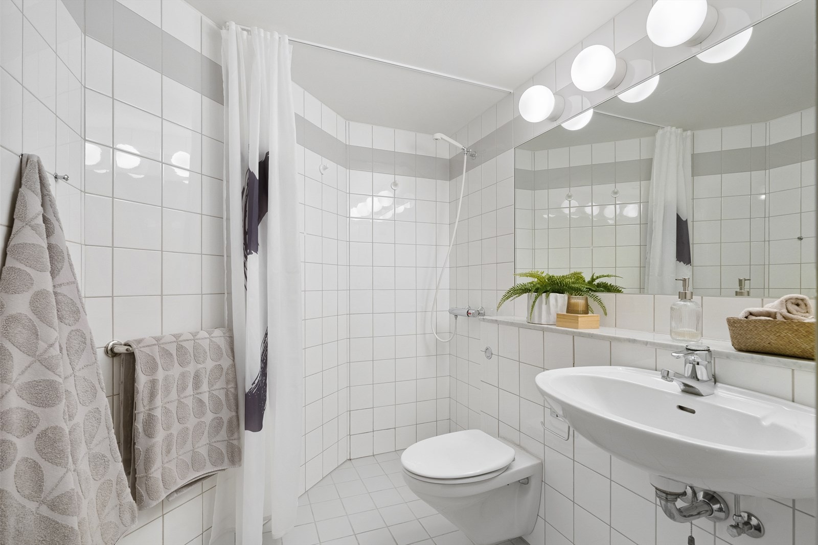 Badet i 7. etasje er innredet med enkel servant, veggmontert toalett og dusj med forheng. Galleribilde